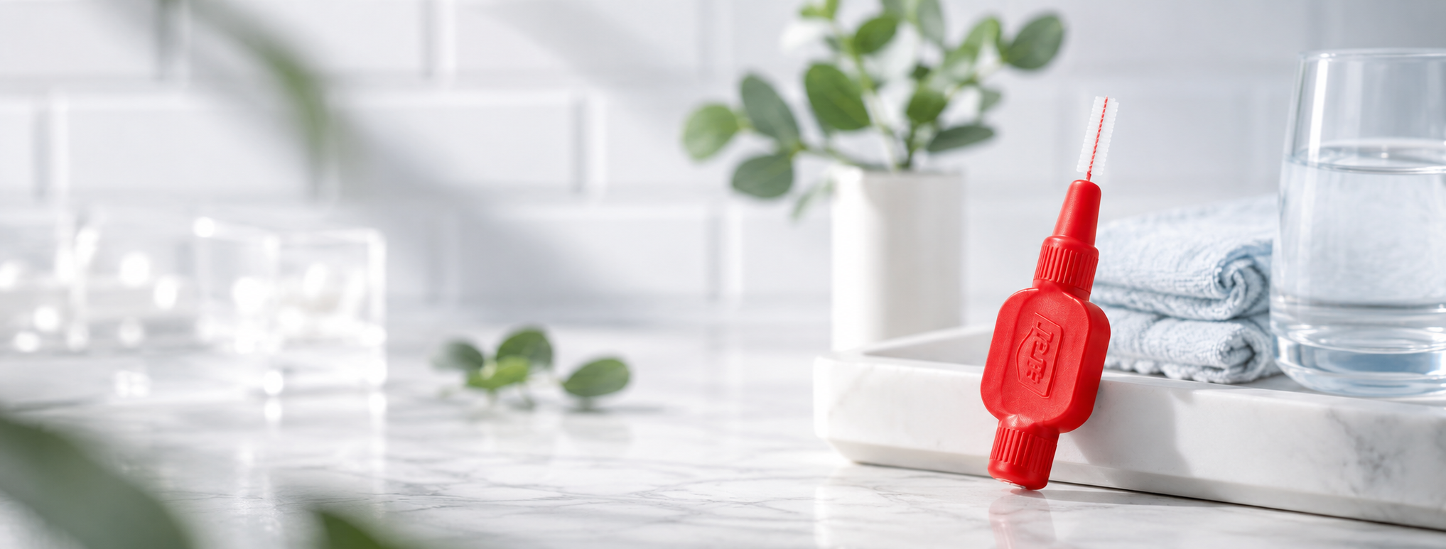 TePe ragertjes rood op marmeren badkamerblad met handdoek en glas water