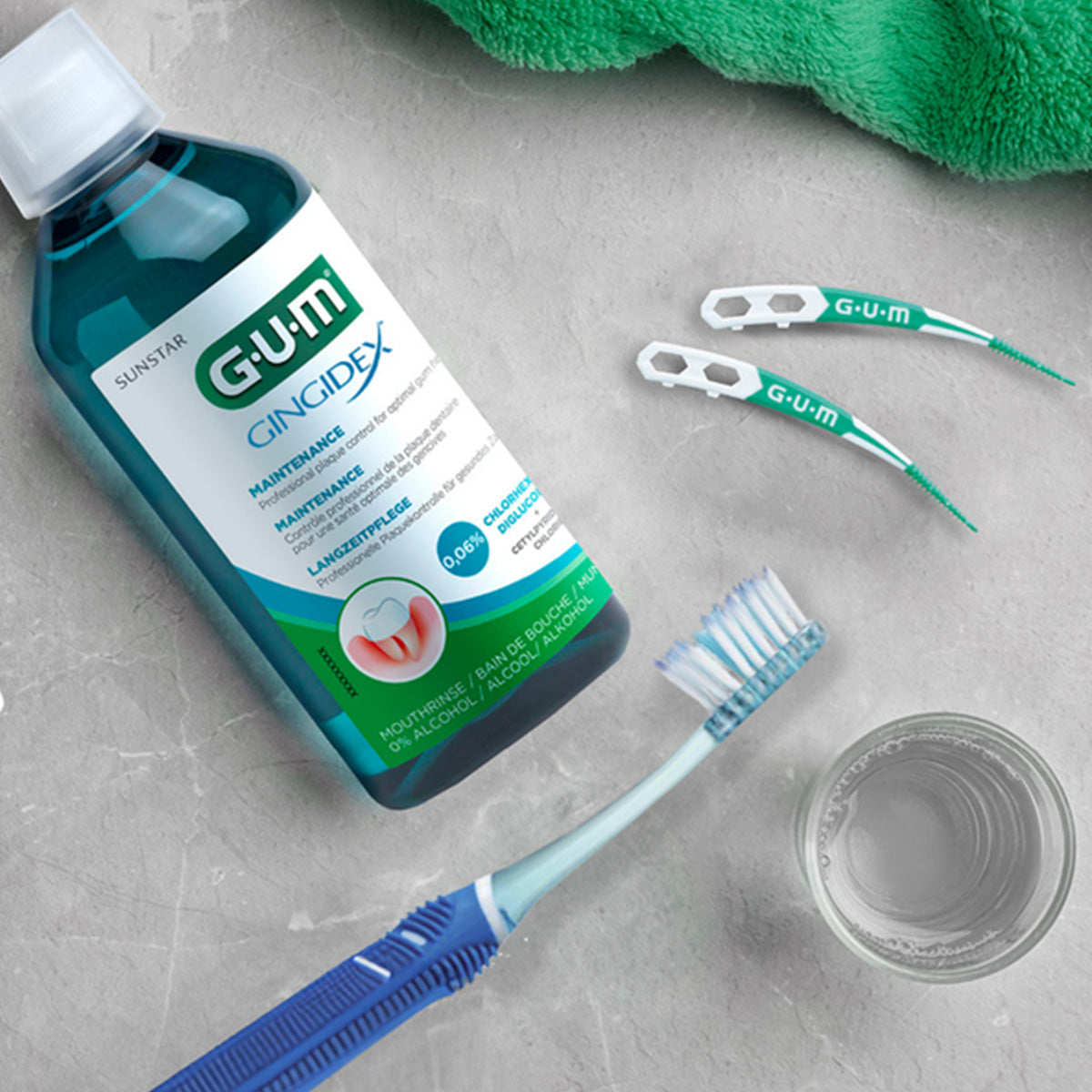 GUM Gingidex mondspoelmiddel naast tandenborstel, glas water en tanddraadstokjes