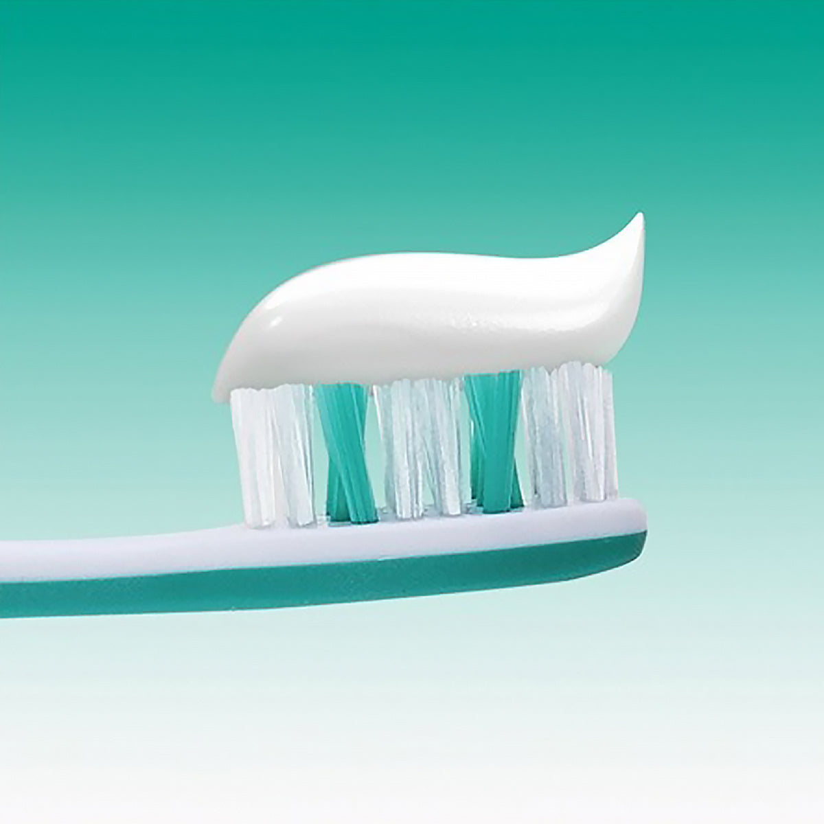 Elmex Sensitive Gentle White tandpasta op tandenborstel met turquoise haren