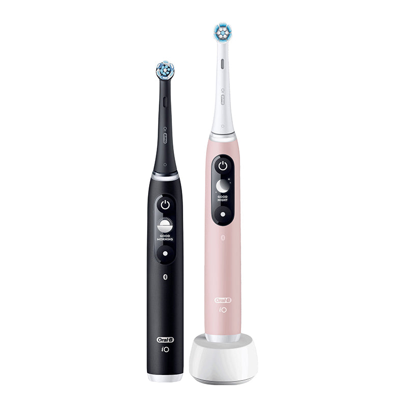 Oral-B iO 6 Black Lava en Pink Sand elektrische tandenborstels naast elkaar op oplaadstandaard