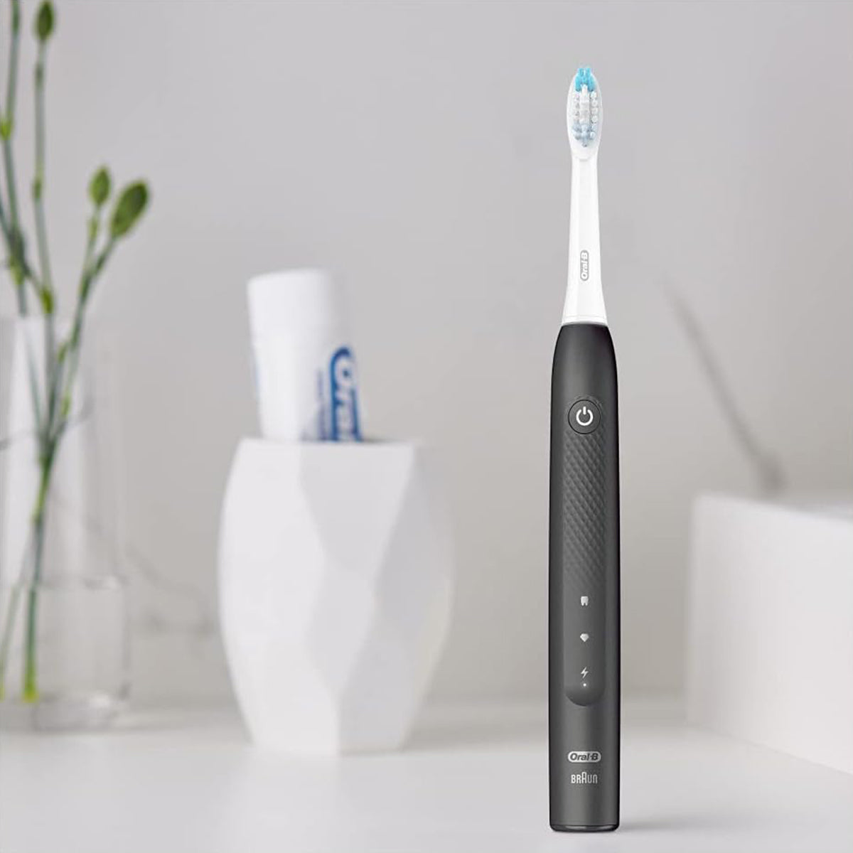 Oral-B Pulsonic Slim Clean 2000 zwart rechtop op badkamermeubel bij plant