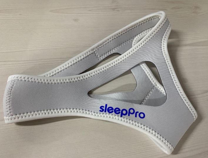 SleepPro Chin Strap Anti-Snurk Kinband grijze kinband op houten ondergrond