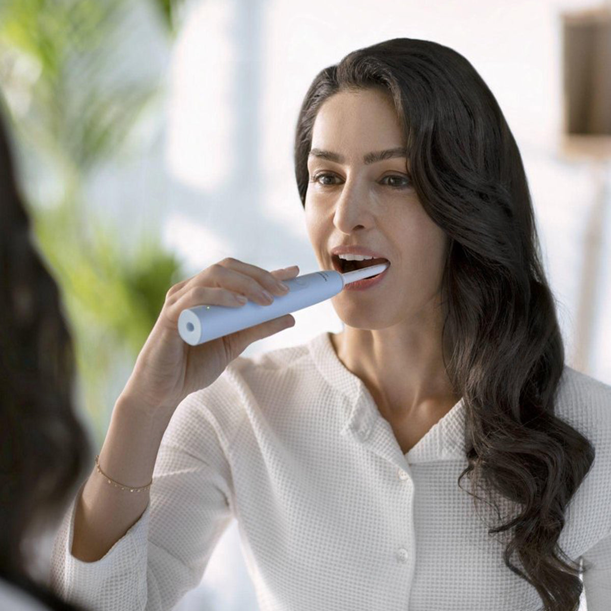 Sonicare 2100 elektrische tandenborstel blauw, vrouw poetst haar tanden