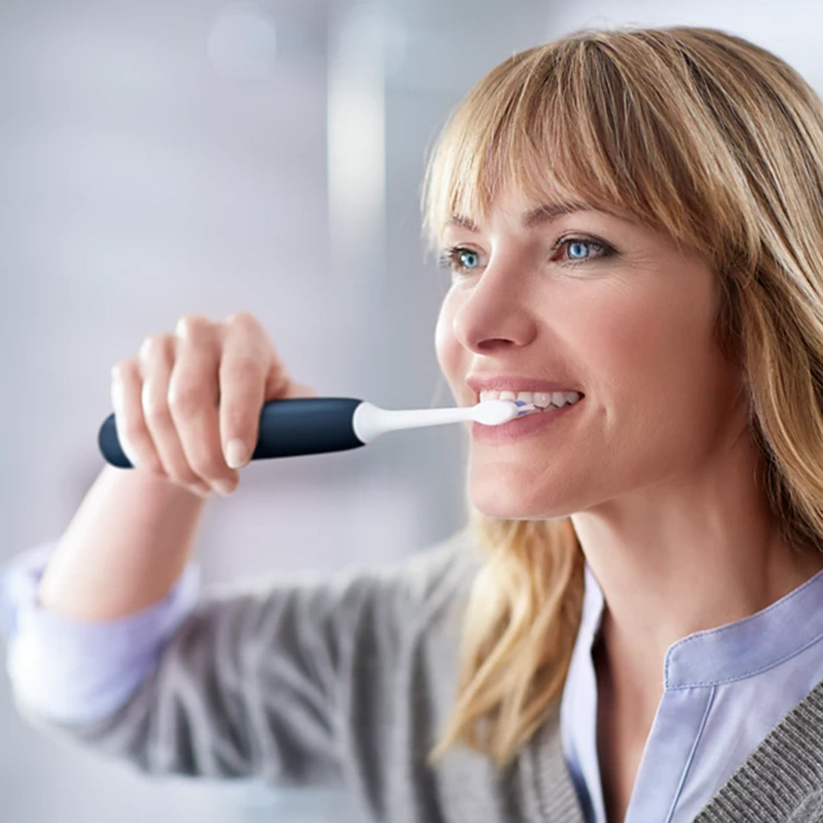 Sonicare Protective Clean elektrische tandenborstel gebruikt door glimlachende vrouw