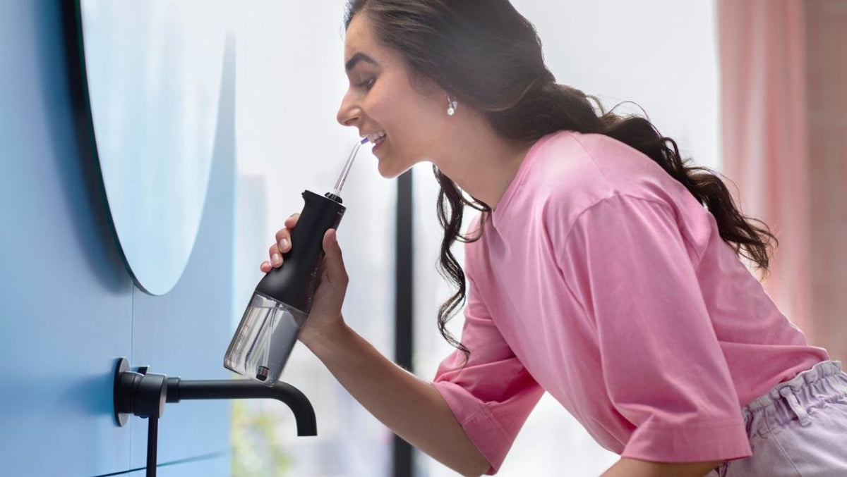 Sonicare Cordless Powerflosser 3000 gebruikt door vrouw bij badkamerkraan