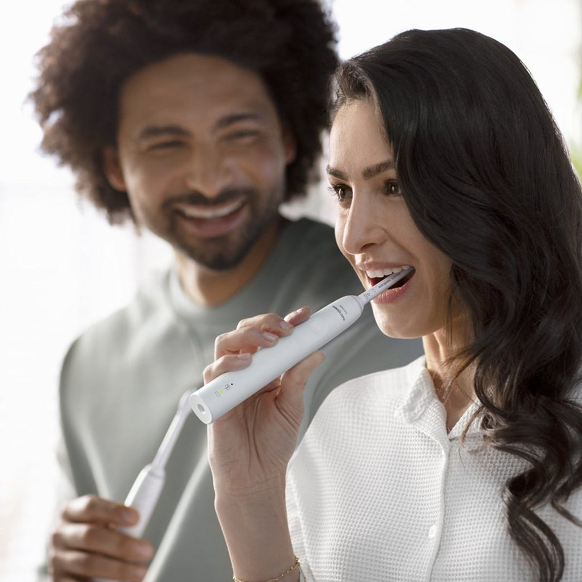 Sonicare 3100 elektrische tandenborstel wit tijdens gebruik door lachende vrouw