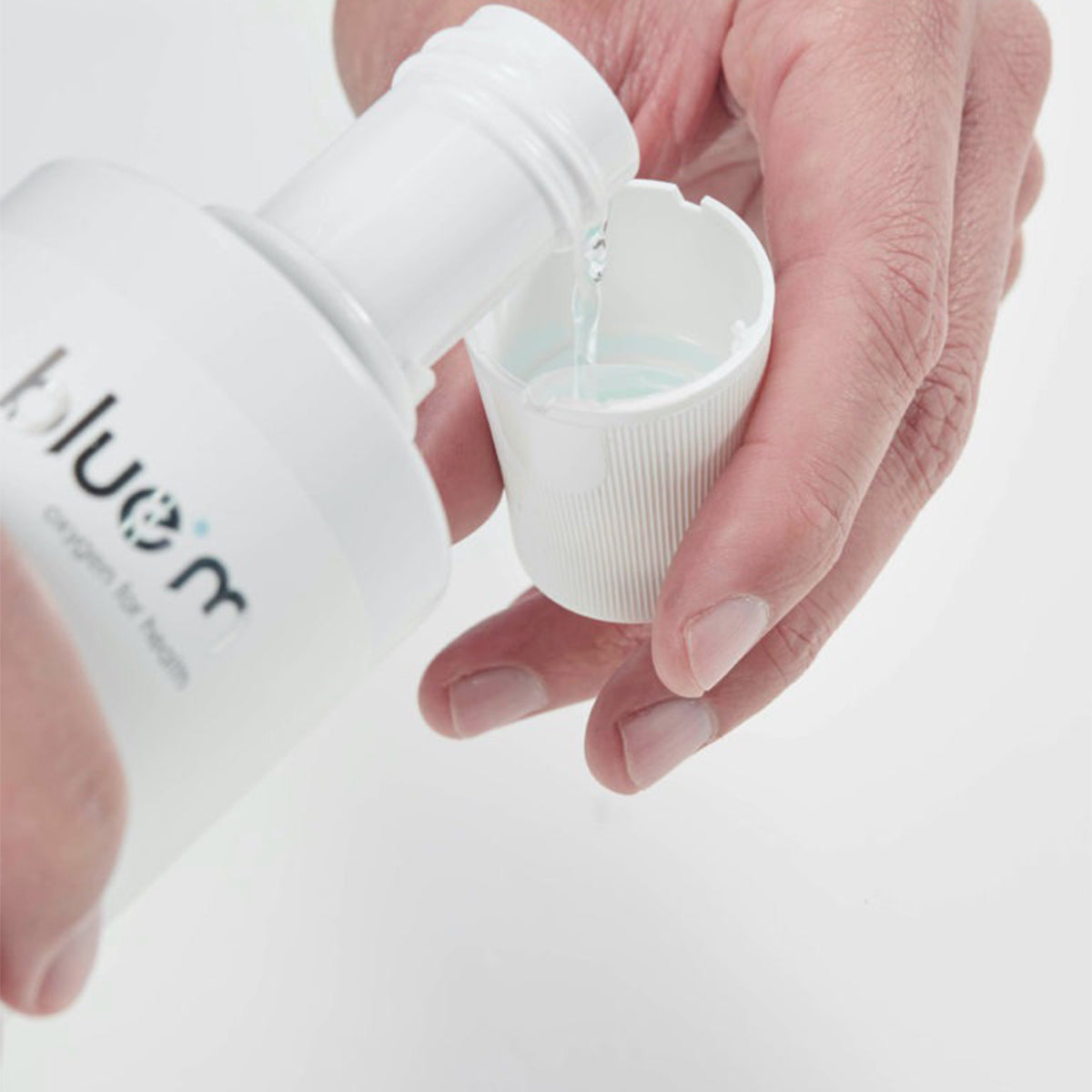 Bluem Oxygen Fluid vloeistof wordt uit fles in dopje gegoten