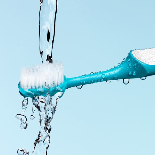 TePe Supreme tandenborstel met waterstroom en druppels op blauwe achtergrond