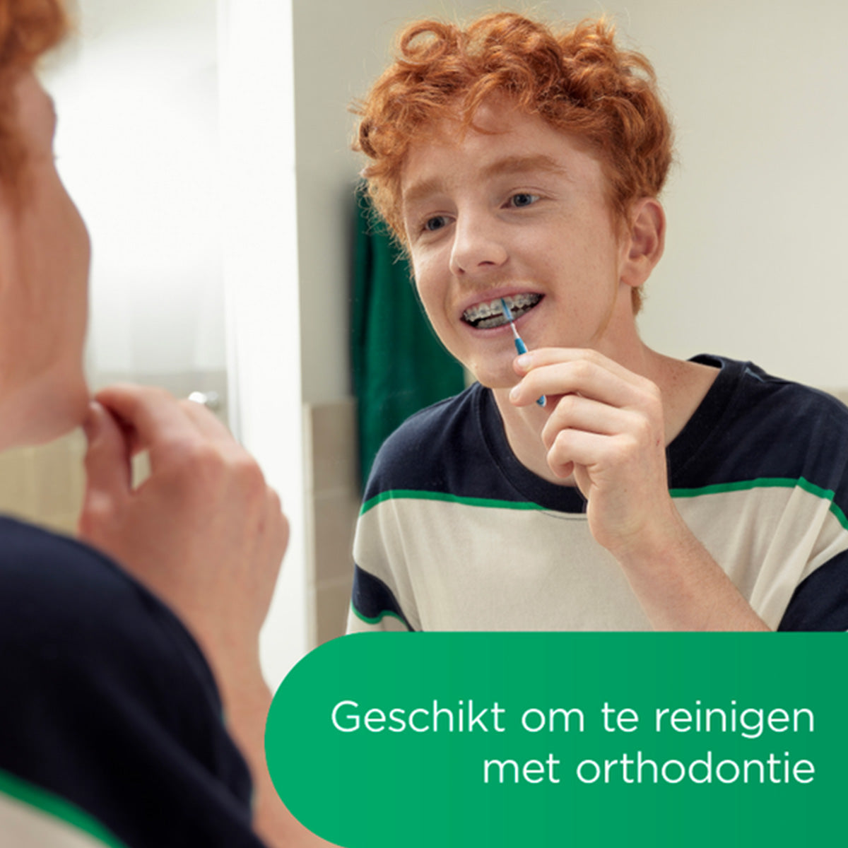 Gum Trav-Ler 1,3mm geel, jongen met beugel poetst tussen tanden voor spiegel