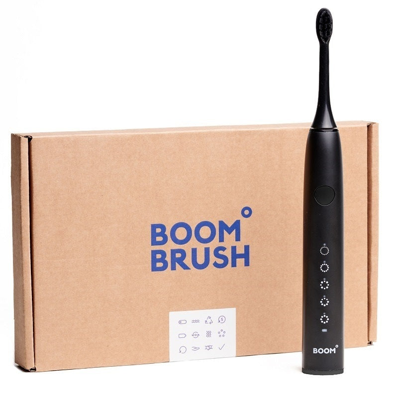 Boombrush Sonische tandenborstel zwart naast bruine kartonnen verpakking