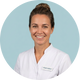 Lachende mondhygiënist in wit uniform met naamlabel op lichtblauwe achtergrond