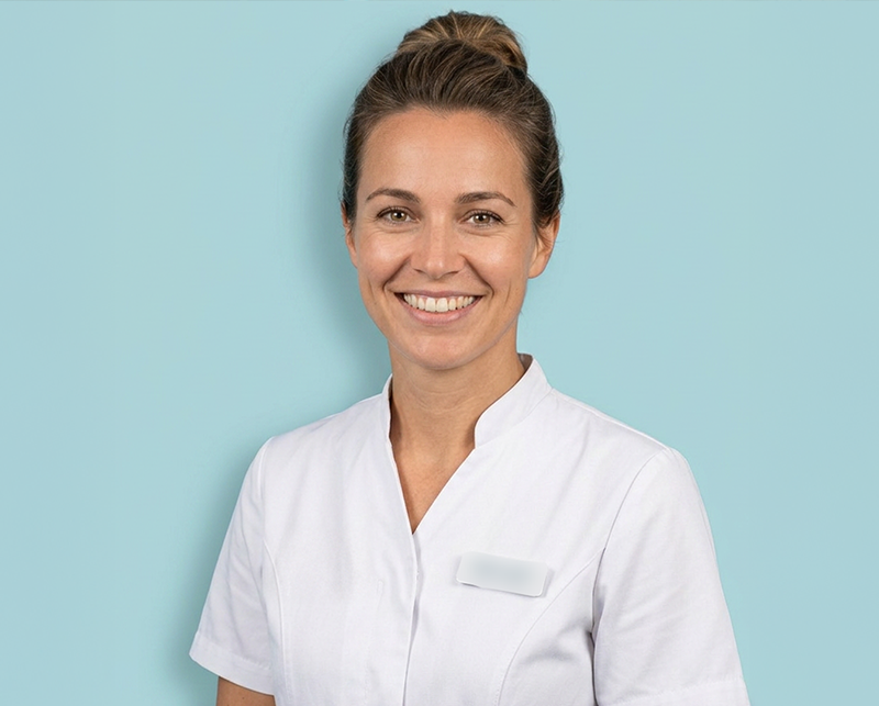 Lachende mondhygiëniste in wit uniform tegen lichtblauwe achtergrond